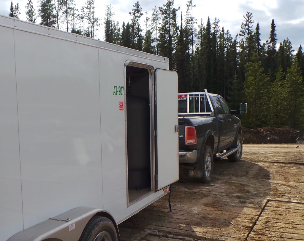 Trailer hitched on a black truck that is onsite at an oil sands site to install industrial automation products